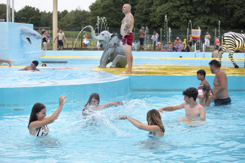 Niños y adultos juegan en la piscina con figuras de animales en el parque Recreatieoord Wilhelm Tell, Bélgica.