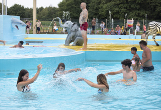 Børn og voksne leger i poolen med dyrefigurer i ferieparken Recreatieoord Wilhelm Tell i Belgisk Limburg.