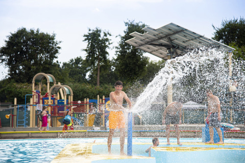 Niño juega con un gran chorro de agua en un parque acuático exterior en Recreatieoord Wilhelm Tell, Limburgo, Bélgica.
