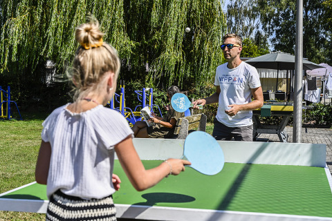 To personer spiller bordtennis udendørs i solskin på Recreatiepark de Lucht, Utrecht, Holland.