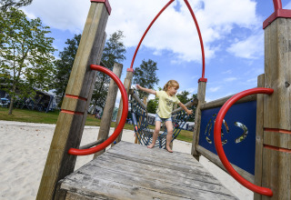 Et barn leger på en legeplads i sandet ved Recreatiepark de Lucht, et feriepark i Utrecht, Holland.