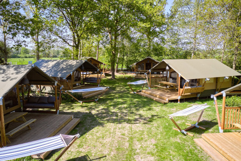 Cozy glamping tents and hammocks set in a green area at Recreatiepark de Lucht, Utrecht, Netherlands.