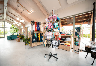 Butik i Vakantiepark De Nollen med tøj, sandaler og souvenirs, lyst interiør i feriepark i Holland.