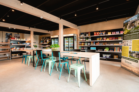 Bright shop interior at Vakantiepark De Nollen, North Holland, Netherlands, with tables, chairs and shelves.