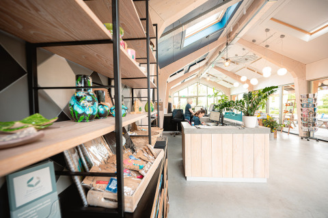Recepción moderna en Vakantiepark De Nollen, Holanda Septentrional, con plantas y recuerdos en estantes.