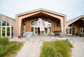 Edificio moderno in legno all’ingresso di Vakantiepark De Nollen in Olanda Settentrionale, Paesi Bassi, con giardino.