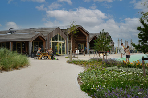 Außenaufnahme von Vakantiepark De Nollen in Nordholland, Niederlande, mit Menschen und moderner Holzhütte.