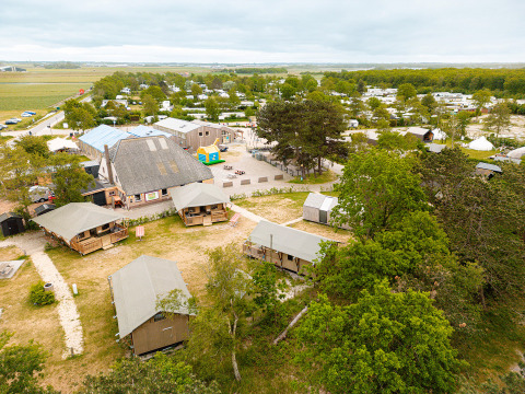 Vista aérea de Vakantiepark De Nollen, con tiendas, cabañas y zonas verdes en un parque de vacaciones holandés.