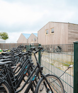 Fahrräder am Zaun neben einer aufblasbaren Giraffen-Hüpfburg im Vakantiepark De Nollen, Nordholland.