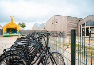 Vélos près d'une grille et château gonflable girafe au Vakantiepark De Nollen, Hollande-Septentrionale.
