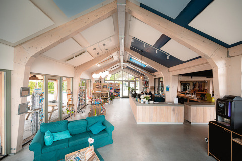 Moderne Rezeption mit Holzbalken und Sofa im Vakantiepark De Nollen, Ferienpark in Nordholland, Niederlande.