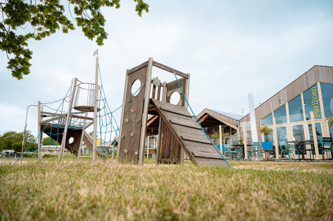 Spielplatz und Pavillon im Ferienpark De Nollen, Nordholland, Niederlande, an einem klaren Tag.