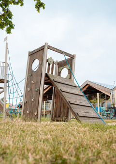 Speeltuin en paviljoen bij vakantiepark De Nollen, Noord-Holland, Nederland op een zonnige dag.