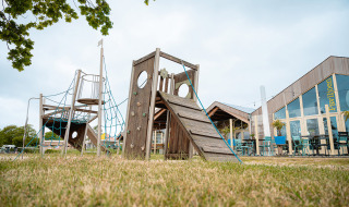 Spielplatz und Pavillon im Ferienpark De Nollen, Nordholland, Niederlande, an einem klaren Tag.