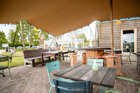 Gemütlicher Außenbereich mit Holzmöbeln im Vakantiepark De Nollen, Nordholland, Niederlande.