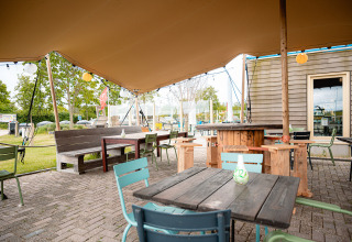 Gemütlicher Außenbereich mit Holzmöbeln im Vakantiepark De Nollen, Nordholland, Niederlande.