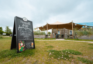 Außenaufnahme eines Restaurants mit Tafel im Vakantiepark De Nollen, einem Ferienpark in Nordholland, Niederlande.