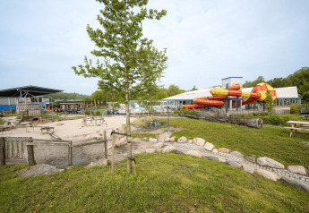 View of Holiday Park Ackersate featuring Villatent Cottage safari tent and colorful water slides in the Netherlands.
