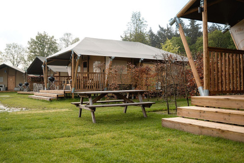 Photo of safari tents Villatent Cottage at Holiday Park Ackersate in the Netherlands with wooden decks and lawn.