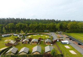 Vista aérea de las tiendas safari Villatent Cottage en Holiday Park Ackersate, Países Bajos, junto al bosque.