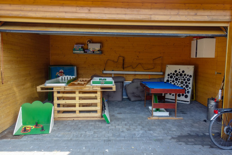 Blick in einen Freizeitraum mit Spieltischen und Relaxmöbeln im Ferienpark Camping Bockenauer Schweiz.