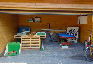 Sala ricreativa con tavoli da gioco e arredi per il relax al Camping Bockenauer Schweiz, Germania.