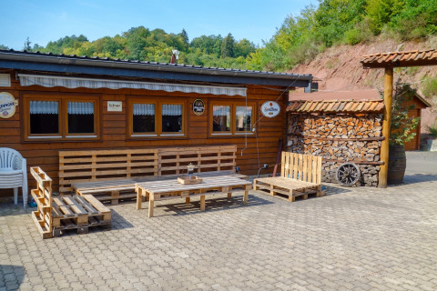 Area relax esterna al Camping Bockenauer Schweiz con mobili in pallet e legna in Renania-Palatinato, Germania.