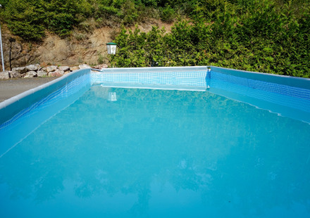 Rechthoekig zwembad op Camping Bockenauer Schweiz in Rijnland-Palts, omgeven door veel groen.