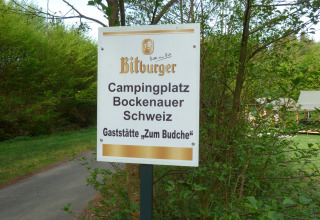 Cartello di Camping Bockenauer Schweiz, villaggio vacanze in Renania-Palatinato, Germania, immerso nel verde.