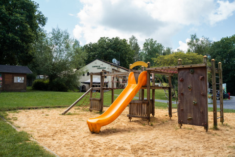 Parco giochi con scivolo giallo e parete da arrampicata al Camping de Chênefleur, Lussemburgo, Belgio.