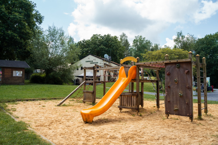 Playground with yellow slide and climbing wall at Camping de Chênefleur holiday park in Luxembourg, Belgium.