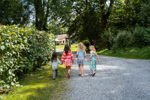 Cuatro niños caminan por una senda entre árboles en Camping de Chênefleur, Bélgica Luxemburgo.