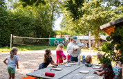 Bambini fanno lavoretti all'aperto a un tavolo nel Camping de Chênefleur, parco vacanze in Lussemburgo belga.
