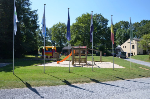 Parque infantil con tobogán y columpios en Camping de Chênefleur, parque vacacional en Bélgica Luxemburgo.
