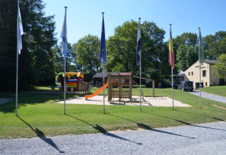 Speeltuin met schommel en glijbaan op Camping de Chênefleur, vakantiepark in Belgisch Luxemburg, België.