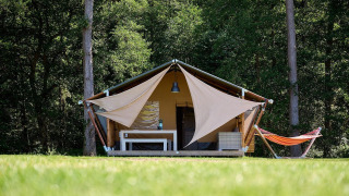 Tienda safari Villatent Nomad en Recreatieoord Wilhelm Tell, Bélgica, rodeada de naturaleza y bosque.