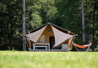 Tienda safari Villatent Nomad en Recreatieoord Wilhelm Tell, Bélgica, rodeada de naturaleza y bosque.