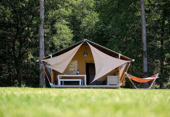 Tienda safari Villatent Nomad en Recreatieoord Wilhelm Tell, Bélgica, rodeada de naturaleza y bosque.