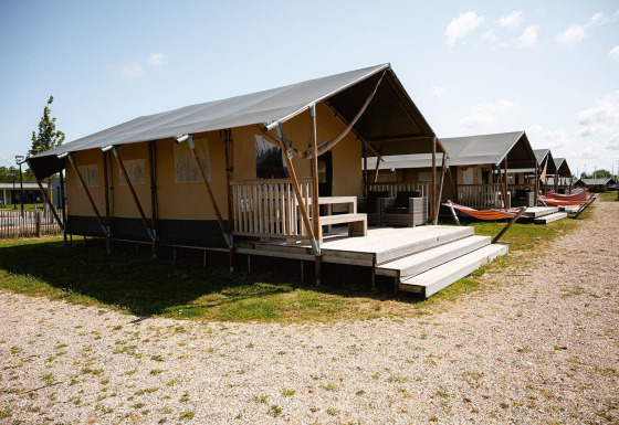Tienda safari Villatent Nomad con terraza y hamacas en el camping RCN de Schotsman en los Países Bajos.