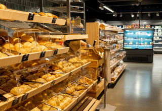 Bakkerijafdeling in een supermarkt in Vakantiepark de Twee Bruggen, Gelderland, met vers brood en broodjes.