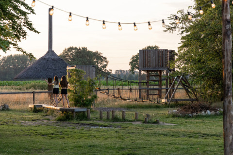 Two girls on a playground with a rope bridge at Vakantiepark de Twee Bruggen, Gelderland, Netherlands.