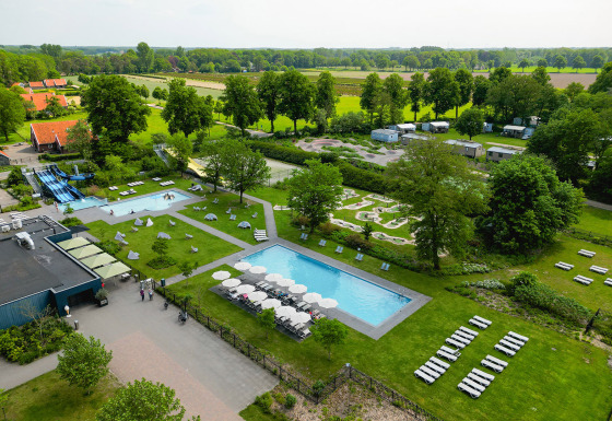 Luchtfoto van Vakantiepark de Twee Bruggen met openluchtzwembaden, ligzetels en chalets in Gelderland.