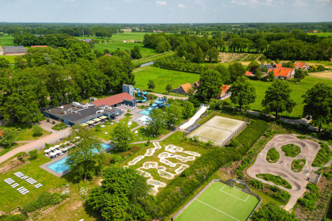 Vista aérea de Vakantiepark de Twee Bruggen en Gelderland, con piscinas, canchas y zonas verdes.