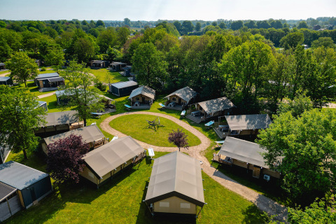 Vista aérea de tiendas y cabañas rodeadas de vegetación en Vakantiepark de Twee Bruggen, Gelderland, Holanda.