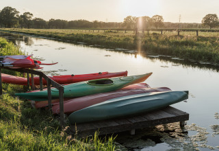 Kayak su un molo lungo un canale al tramonto a Vakantiepark de Twee Bruggen, Gelderland, Paesi Bassi.