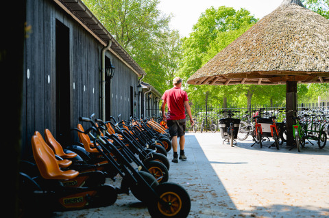 Un homme marche près de karts à pédales et de vélos à Vakantiepark de Twee Bruggen, Gelderland, Pays-Bas.