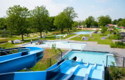 Udendørs swimmingpool med rutsjebaner og græsarealer i Vakantiepark de Twee Bruggen, Gelderland, Holland.