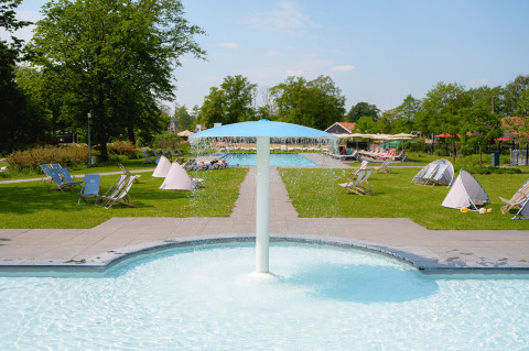 Piscina al aire libre con fuente y tumbonas en Vakantiepark de Twee Bruggen en Gelderland, Países Bajos.