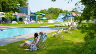 Espace piscine avec transats et toboggans aquatiques au Vakantiepark de Twee Bruggen, Gueldre, Pays-Bas.