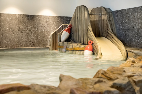 Piscina cubierta con tobogán y boyas en Vakantiepark de Twee Bruggen, parque vacacional de Gelderland.